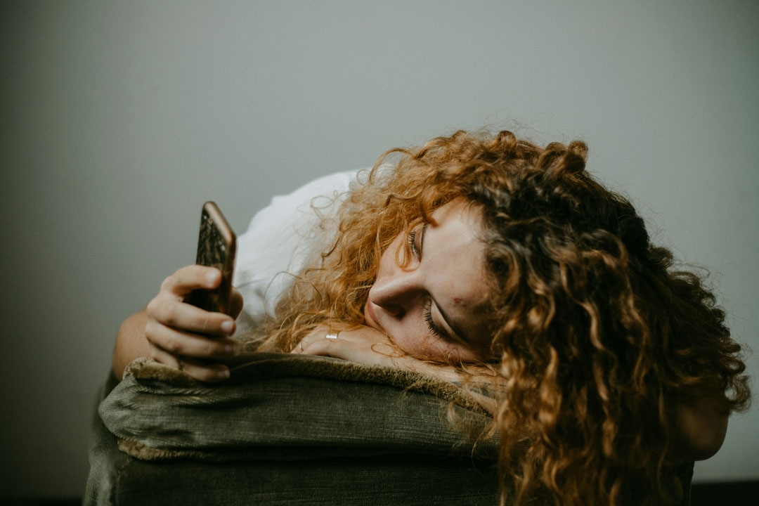 woman-lying-down-holding-smartphone-by-sinitta-leunen-at-unsplash