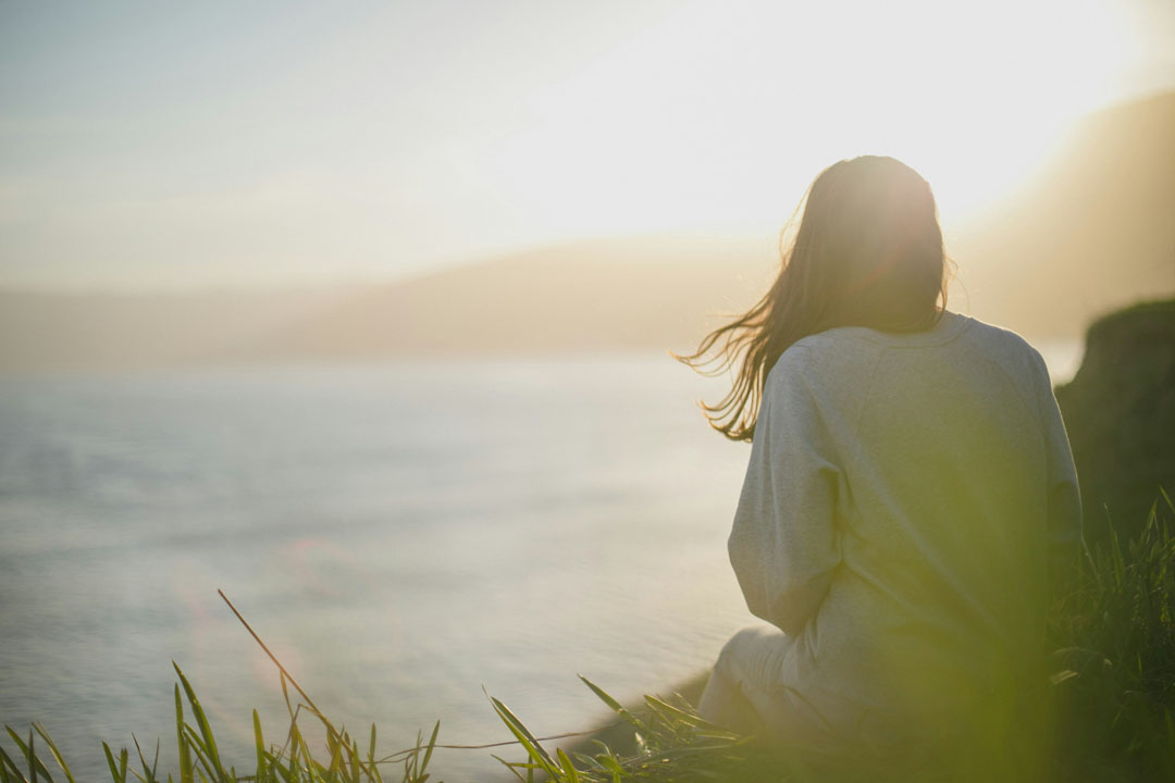 woman-sitting-on-the-mountain-side-watching-the-sea-by-artem-kovalev-at-unsplash